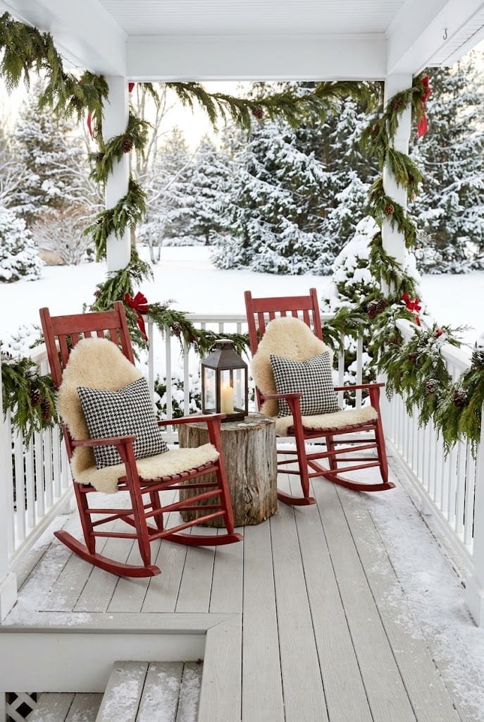Red wooden rocking chairs with shearling pads and lantern for front porch christmas decorating ideas.